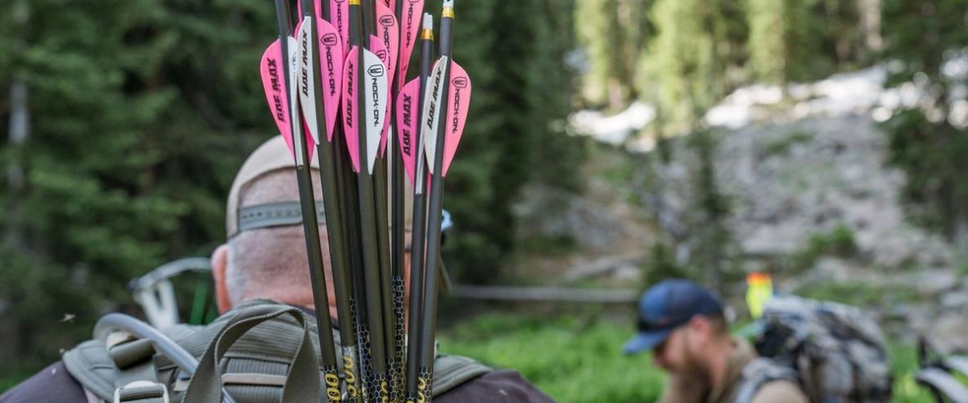 Hunters with arrows and a compound bow in the woods.