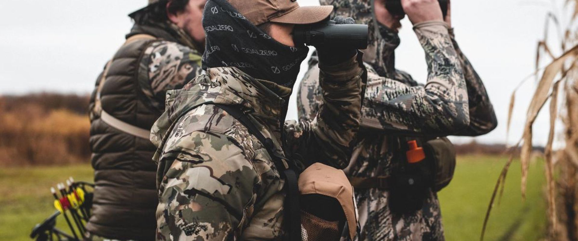 Hunters scouting using binoculars, understanding whitetail facts concept.