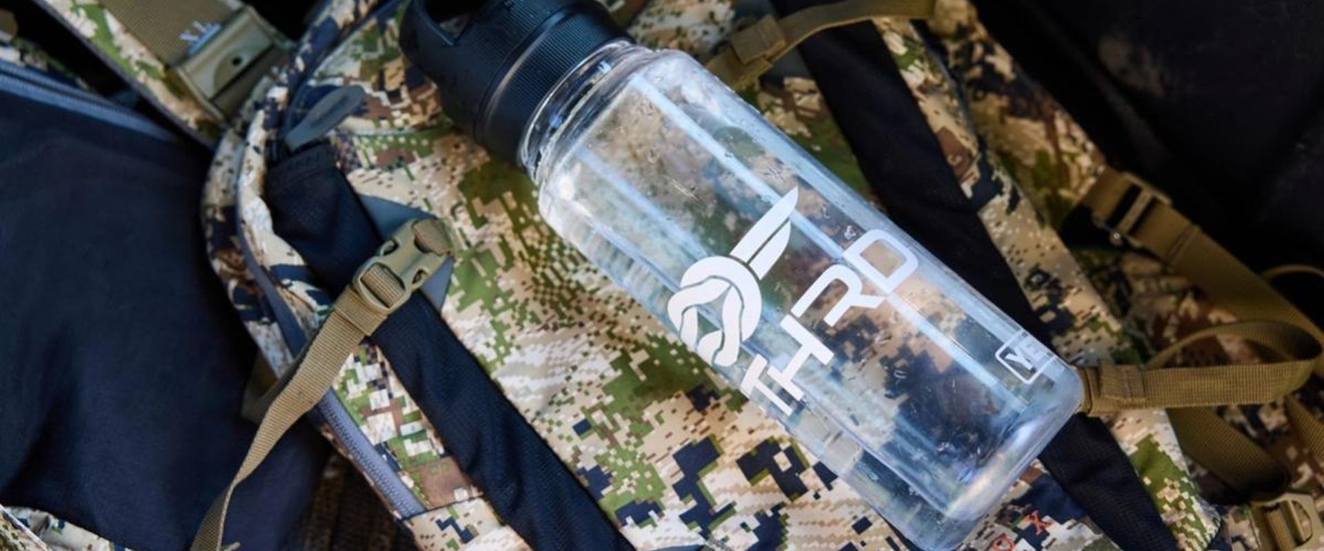 A water bottle on a backpack, hunting in summer tips for staying hydrated concept.