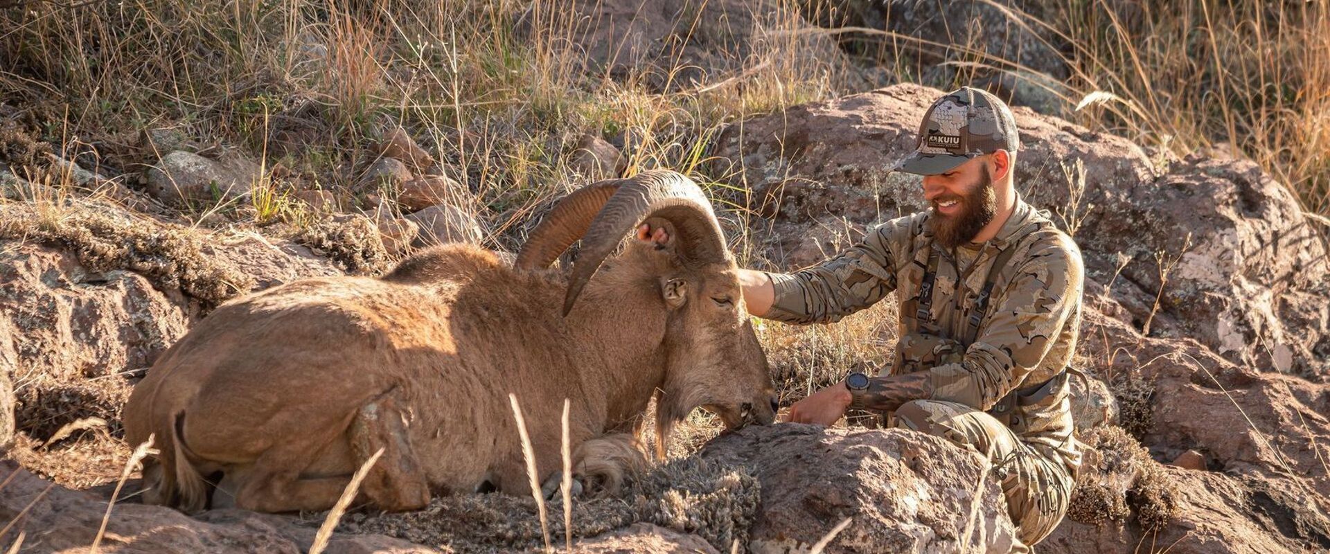 Hunter smiles with bighorn sheep after hunt, surplus hunting tags concept.