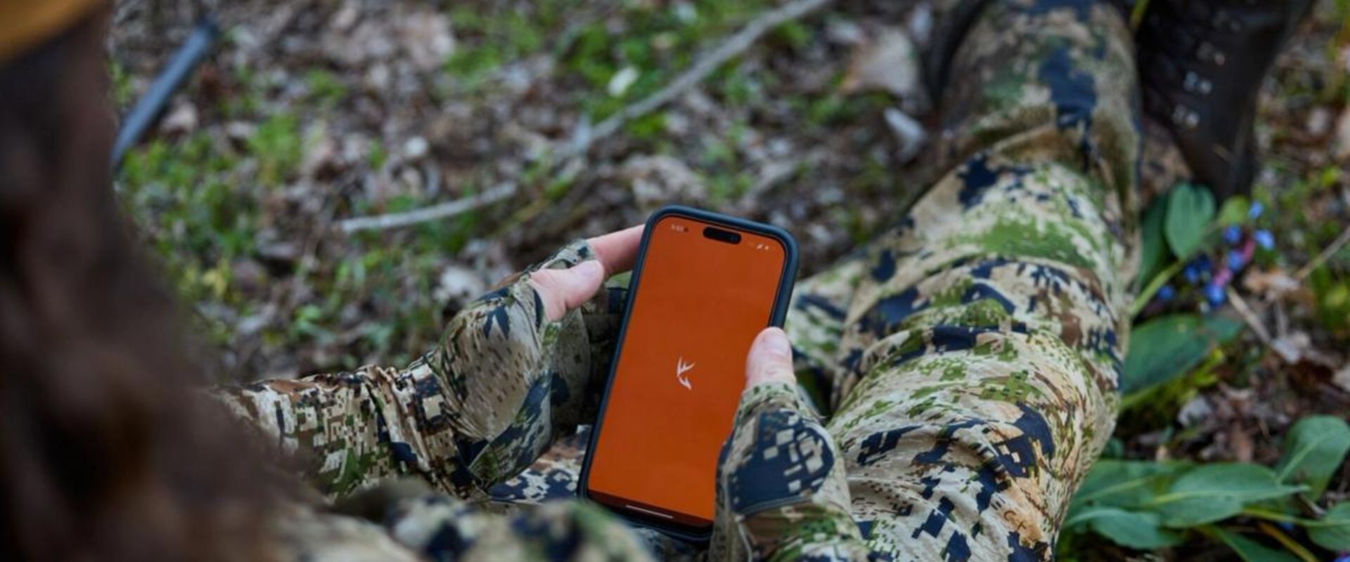 Hand holds phone showing HuntWise on screen, HuntWise vs onX concept. 