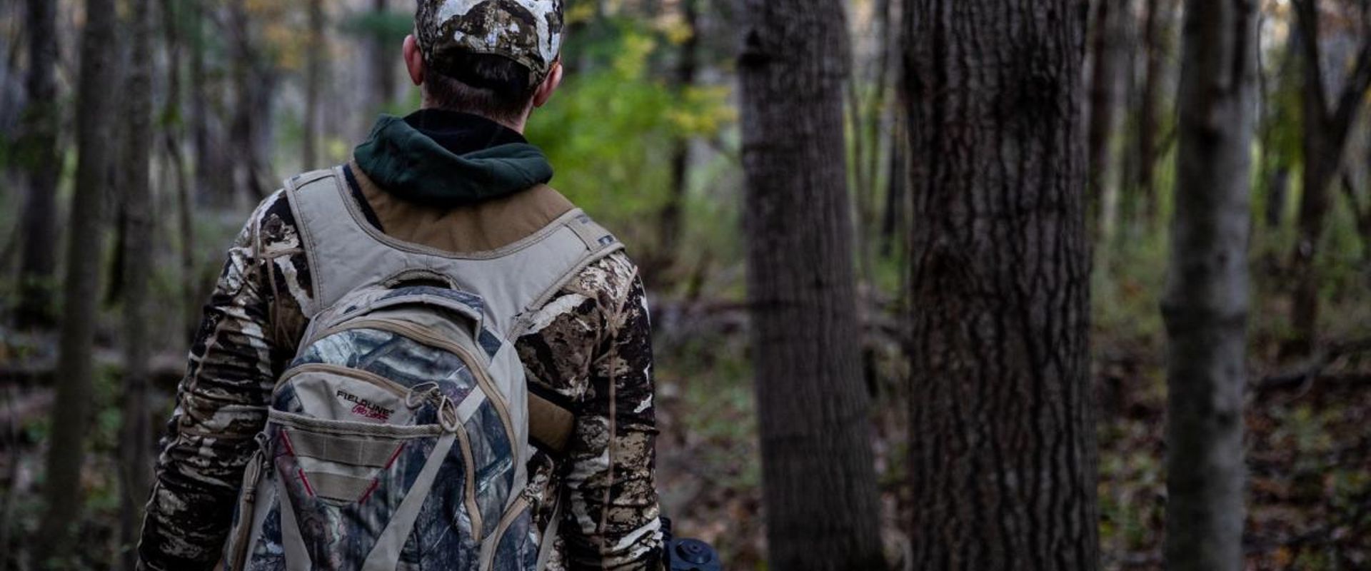 A hunter in the woods with essential hunting gear.