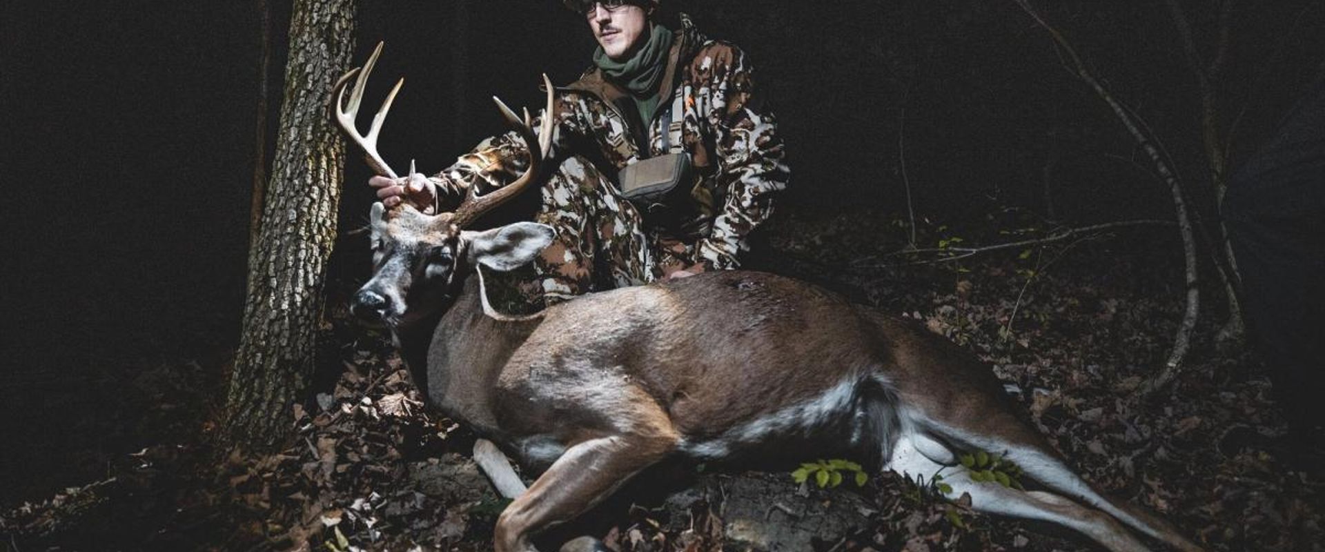 A hunter poses with a trophy buck.