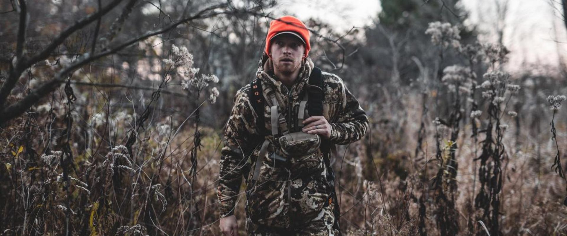 A hunter walking in the brush while wearing camo, get ready for opening day of gun season concept.