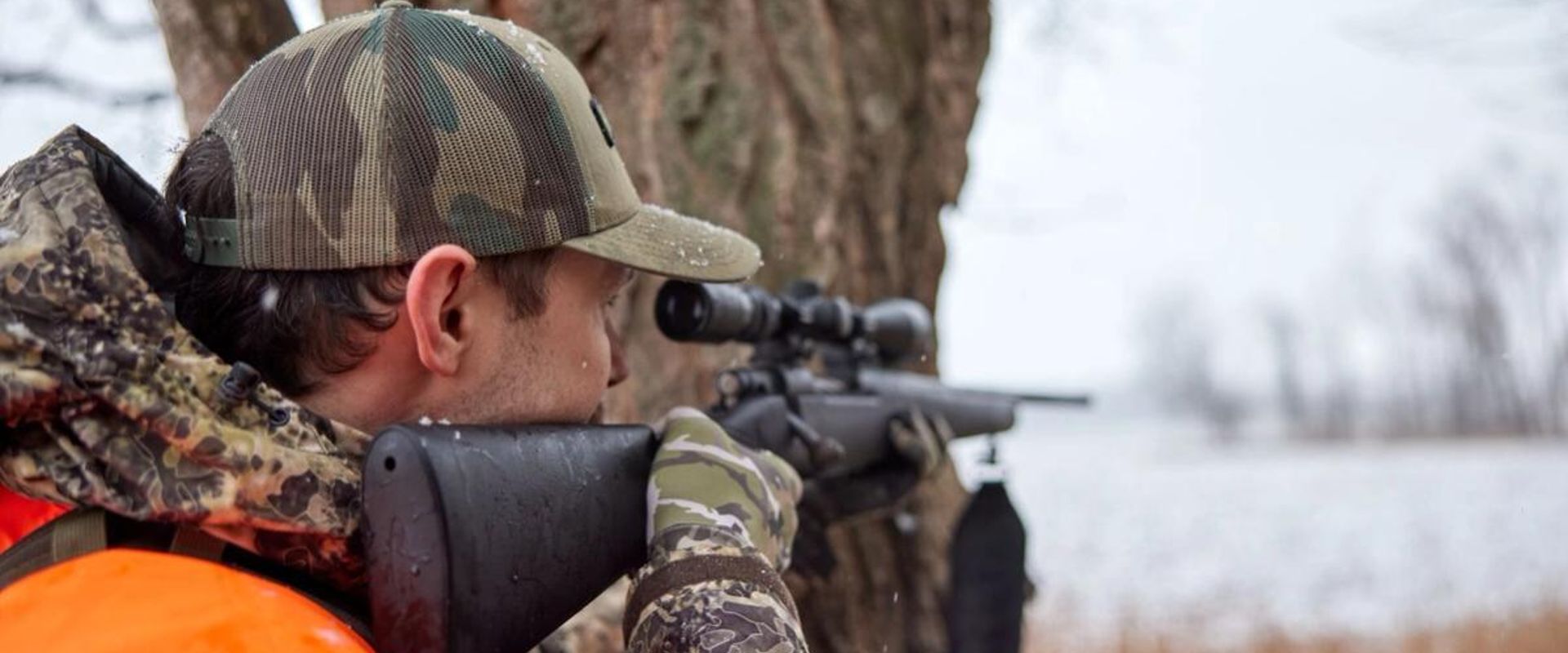 A hunter aims a rifle, choosing the right gun calibers concept.