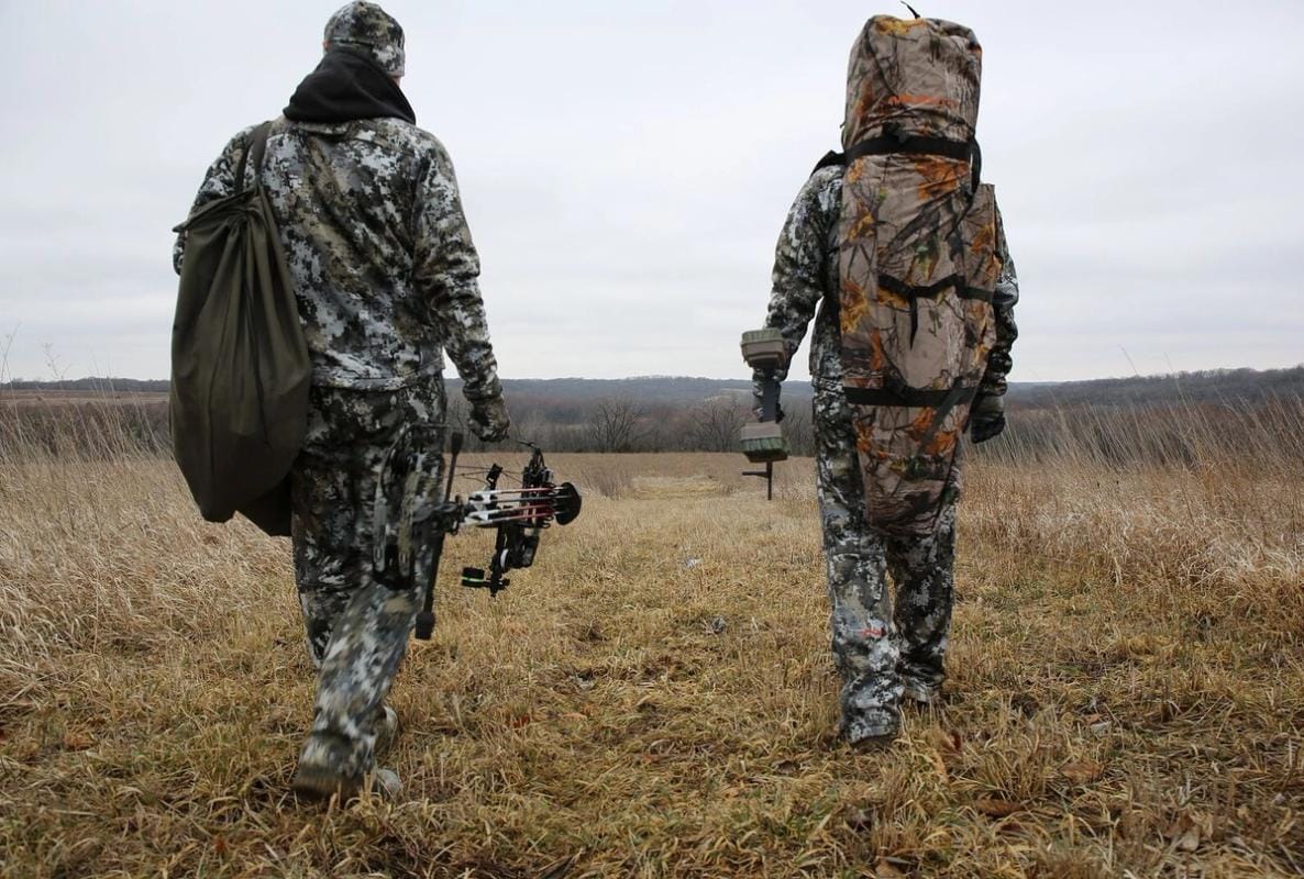 Two hunters walking in a field with text "5 Fall Hunting Tips"