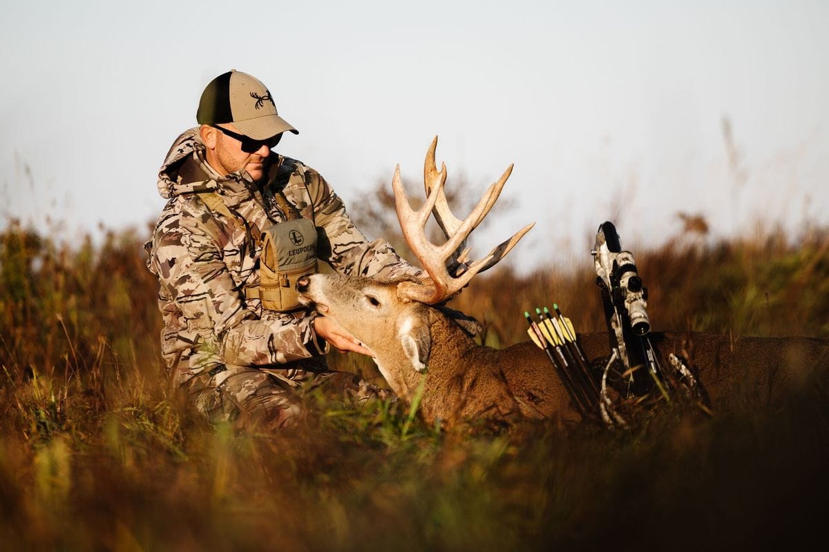 A hunter holds a deer's head and antlers after hunt, what diseases do deer carry concept.