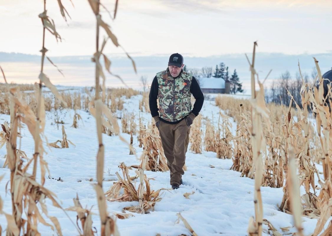 Jeff Sturgis walks through a snowy field, understand weather and deer movement concept.