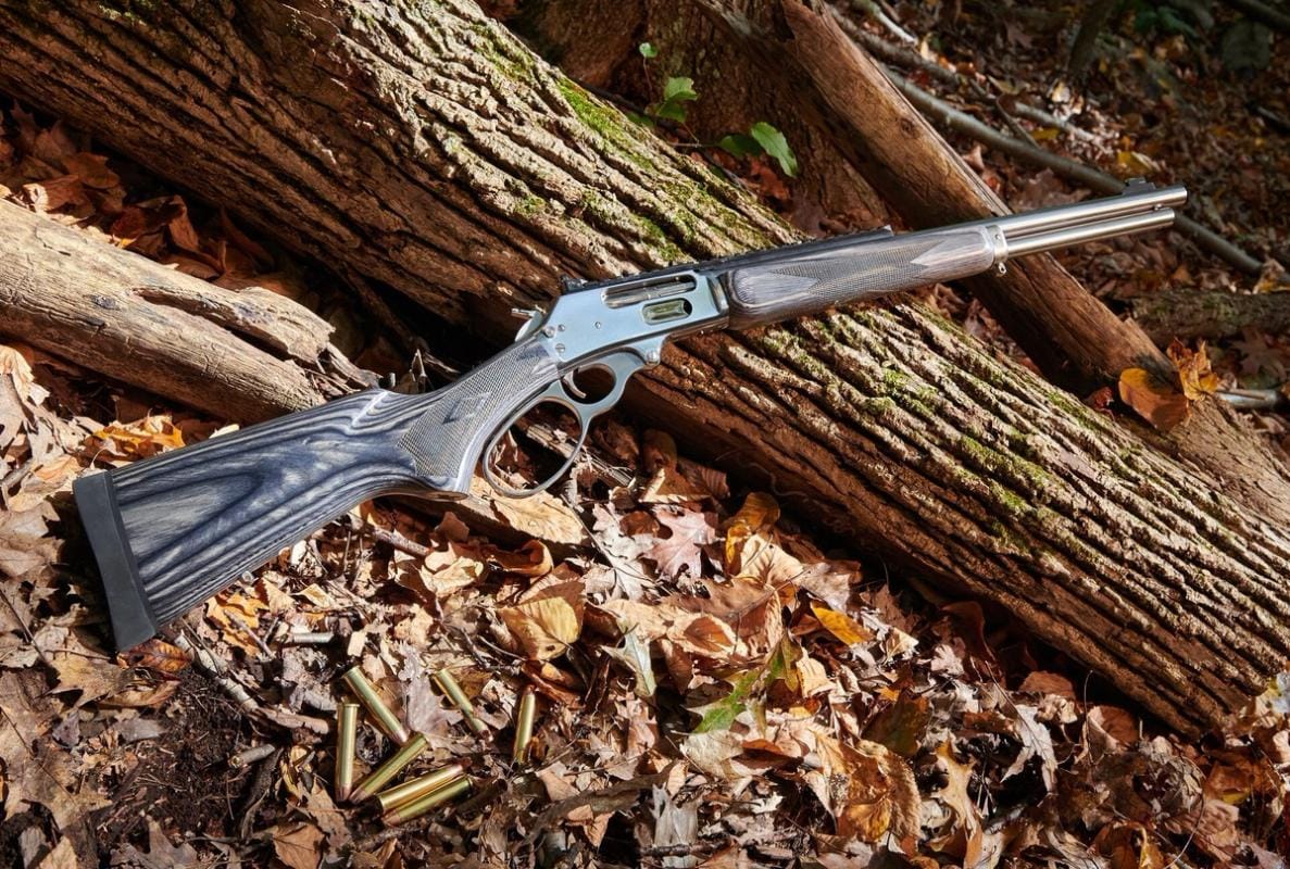 A lever-action rifle on a log, lever action vs bolt action rifles concept.
