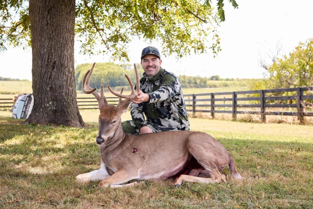 Hunter with buck deer after hunt showing clean shot, where to shoot a deer concept.