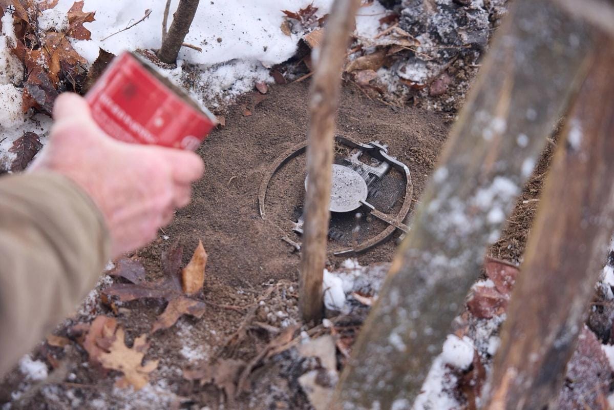Close-up of hands setting animal trap, how to use live animal traps concept.