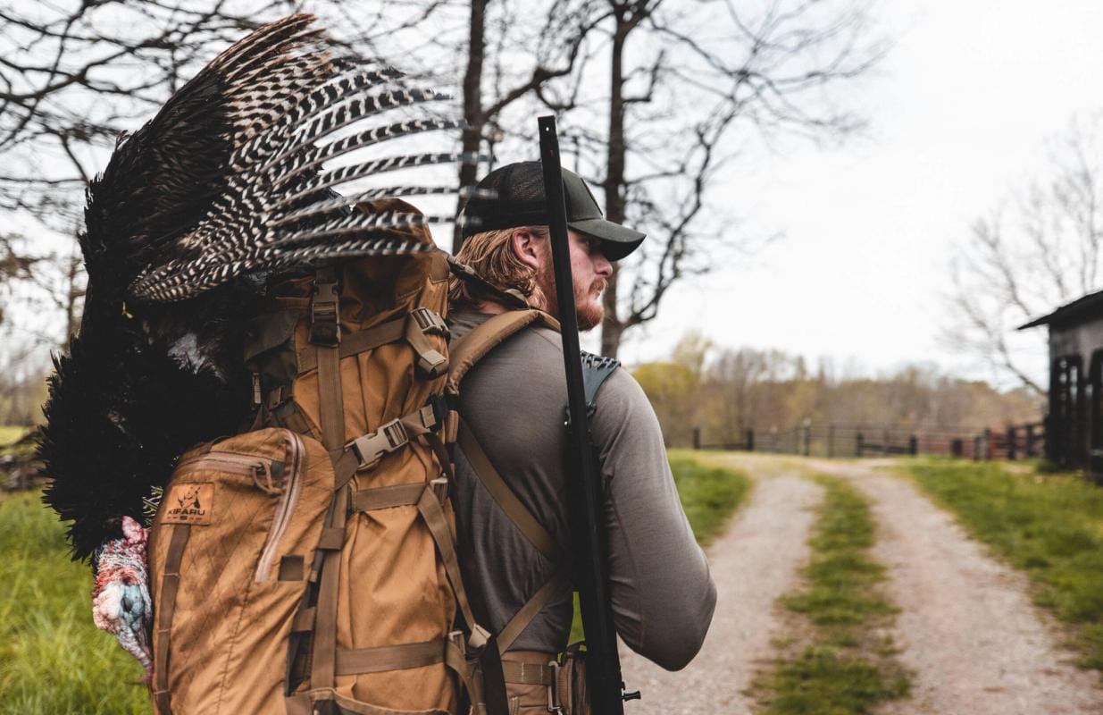 A hunter with a harvested turkey after a successful turkey hunt.