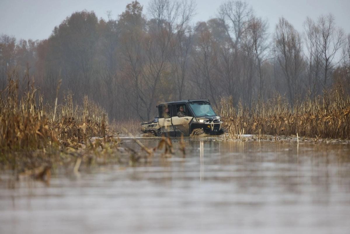 Hunters in an ATV in a duck habitat, building a duck pond concept.