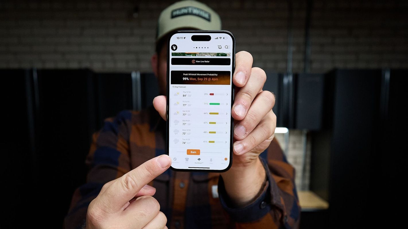 Hunter points at HuntWise HuntCast on phone screen, HuntCast vs weather apps concept.
