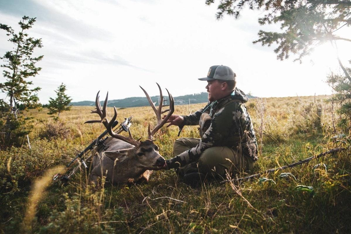 A hunter holds up the head of a deer kill, finding big bucks on public land concept.