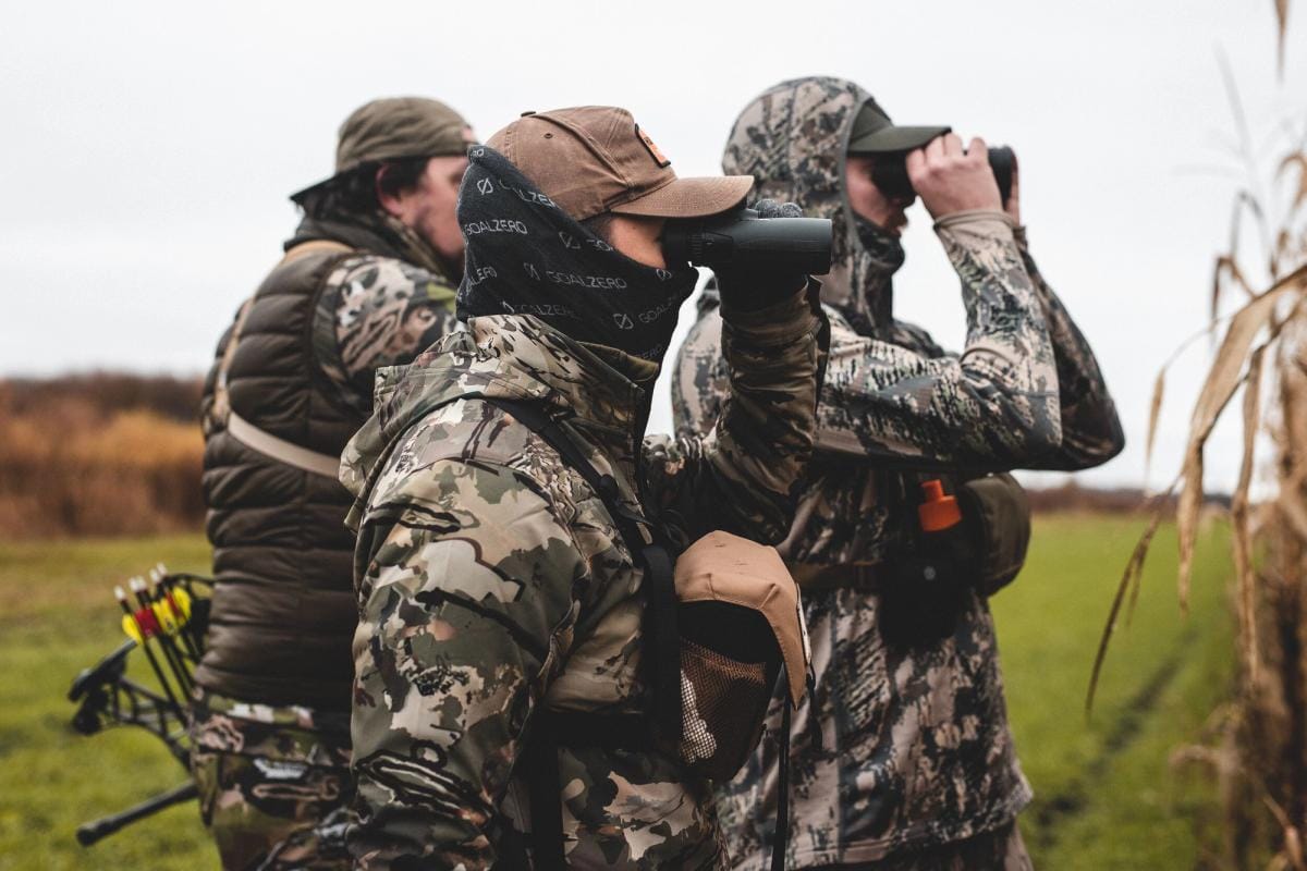 Hunters scouting using binoculars, understanding whitetail facts concept.