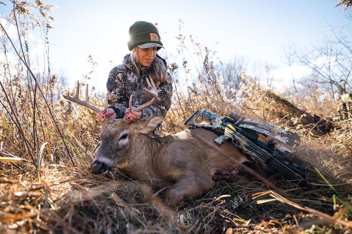A female hunter shows off a deer after a hunt, women's hunting gifts concept.