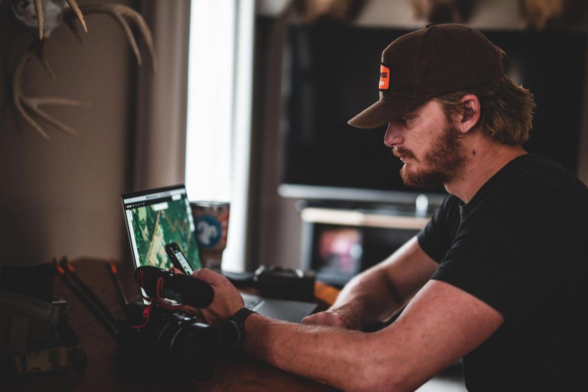 A man looks at a computer with HuntWise on the screen, e scouting for elk concept.
