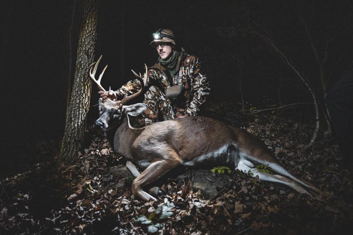 A hunter poses with a trophy buck.