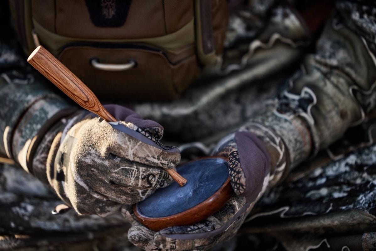A hunter with camera equipment using HuntWise in the field, hunting influencer concept.