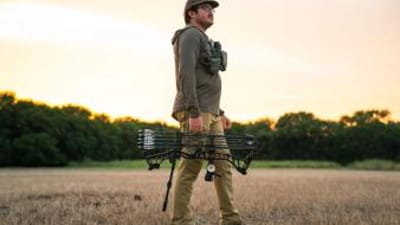 Hunter in field with bow ready for hunt, how to find walk-in hunting in Ohio concept. 