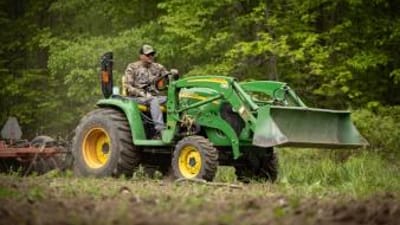 A hunter uses a tractor to clear land, when to plan spring food plots for deer concept.