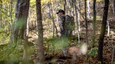 A hunter in camo with gear in the woods, do scent blockers work concept.