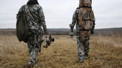 Two hunters walking in a field with text "5 Fall Hunting Tips"