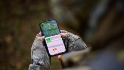 FGBLOG hunter looks at phone showing HuntWise WindCast