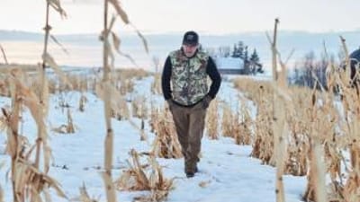 Jeff Sturgis walks through a snowy field, understand weather and deer movement concept.