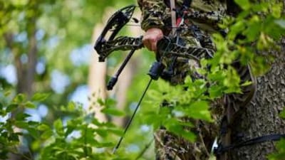 Close-up of a hunter holding a bow at his side, PA archery season concept.