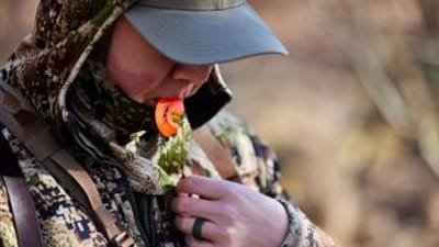 A hunter uses a turkey call, California turkey season concept.