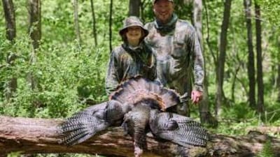 A dad and son in camo after a turkey hunt, hunting gifts for dad concept.