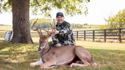 Hunter with buck deer after hunt showing clean shot, where to shoot a deer concept.
