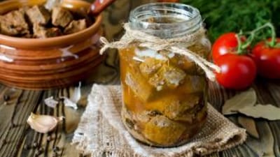 A jar of canned meat on a table, canning venison concept.