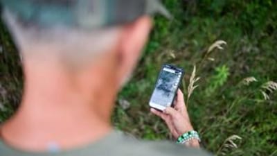 Hunter using the HuntWise land app to find where to hunt.