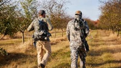 Two hunters walk with gear, how to find walk-in hunting in Wisconsin concept. 
