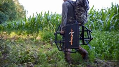 A hunter carries gear and a tree stand to set up for Missouri deer season.