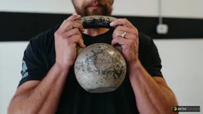 A man holds a dumbbell, hunting exercises to stay in shape concept.