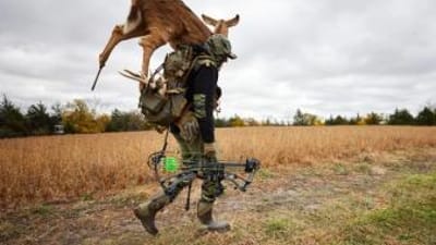 A hunter carries a deer decoy for a hunt.