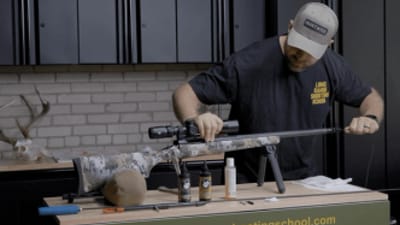 Hunter cleaning a rifle, post season rifle care concept.