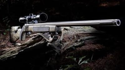 Muzzleloader with scope on log, how to hunt with a muzzleloader concept.