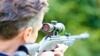 A man aims an air rifle.