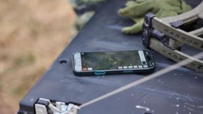Phone on truck tailgate showing hunting app, HuntWise vs GoHunt concept. 