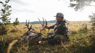 A hunter holds up the head of a deer kill, finding big bucks on public land concept.