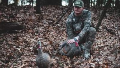 A hunter with a turkey, turkey hunting concept.