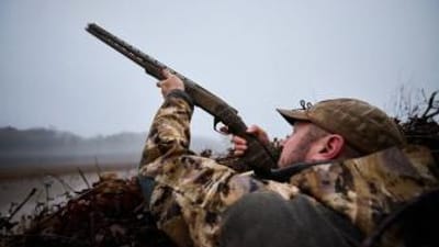 Hunter aiming a shotgun for duck hunt, MN duck opener 2025 concept.