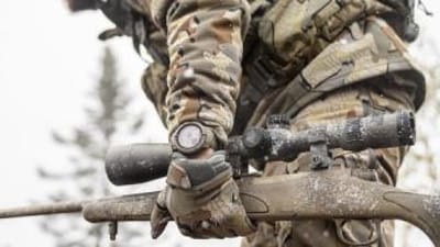 Close-up of a rifle in a hunter's hand, best caliber for whitetail hunts concept.