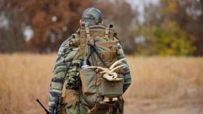 A hunter carries a pack with antler sheds, where to find deers sheds concept.
