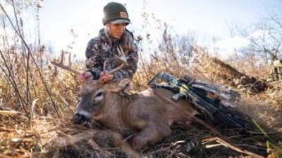 A female hunter shows off a deer after a hunt, women's hunting gifts concept.